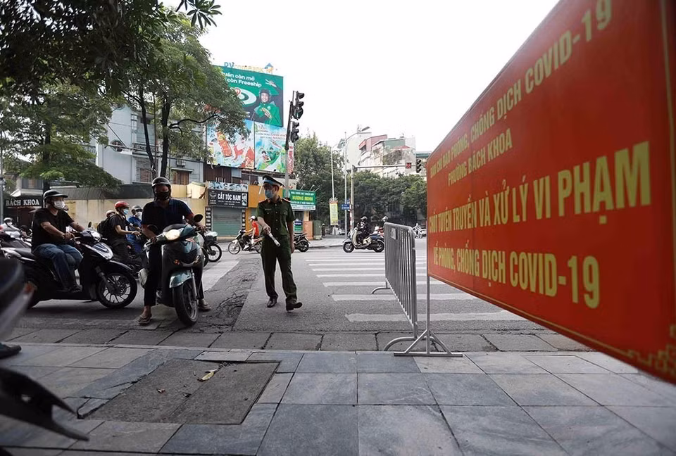 Công an phường Bách Khoa kiểm tra người tham gia giao thông tại chốt phòng, chống dịch trên tuyến phố Lê Thanh Nghị. (Ảnh: Vũ Sinh/TTXVN)