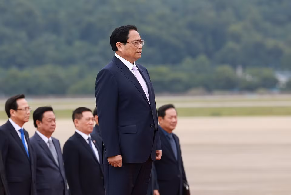 Thủ tướng Phạm Minh Chính nghe quân nhạc cử Quốc thiều. (Ảnh: Dương Giang/TTXVN)