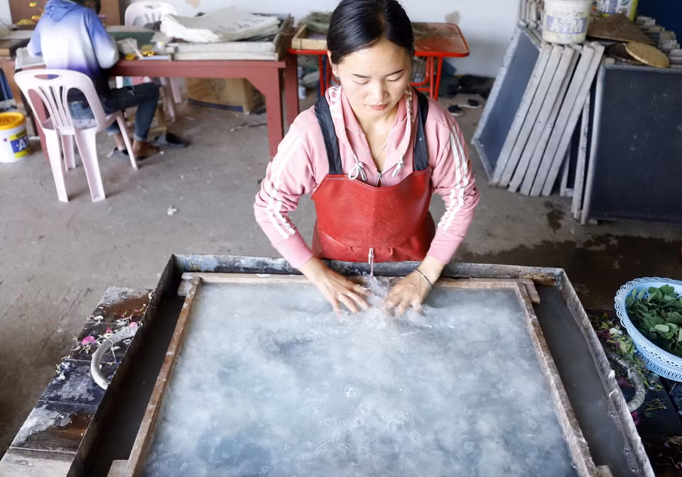 Công đoạn dàn bột giấy trên khuôn. (Ảnh: Phạm Kiên/TTXVN)