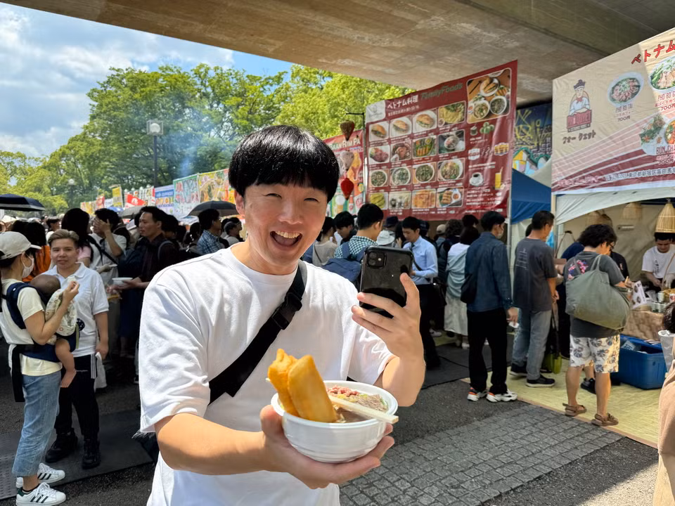Một thanh niên Nhật Bản vui mừng khi mua được một tô phở mà anh nói rằng đúng hương vị phở Hà Nội. (Ảnh: Phạm Tuân/Vietnam+)