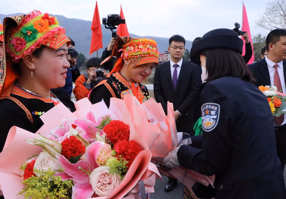 Phía Trung Quốc tặng hoa cho cho người dân Việt Nam xuất cảnh tại khu vực cửa khẩu quốc tế Ma Lù Thàng (Lai Châu, Việt Nam)-Kim Thủy Hà (Trung Quốc). (Ảnh: Nguyễn Oanh/TTXVN) 