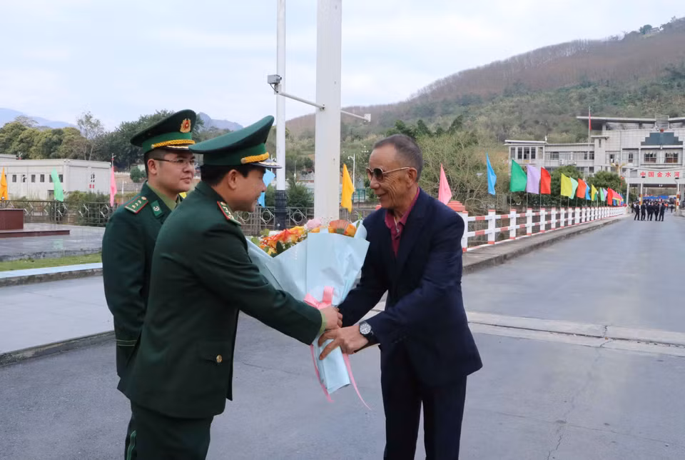 Tặng hoa cho ông Trần Trung Minh ở thấn Kim Thủy Hà, huyện Kim Bình, tỉnh Vân Nam (Trung Quốc) nhập cảnh vào Việt Nam qua Cửa khẩu Quốc tế Ma Lù Thàng. (Ảnh: Nguyễn Oanh/TTXVN)