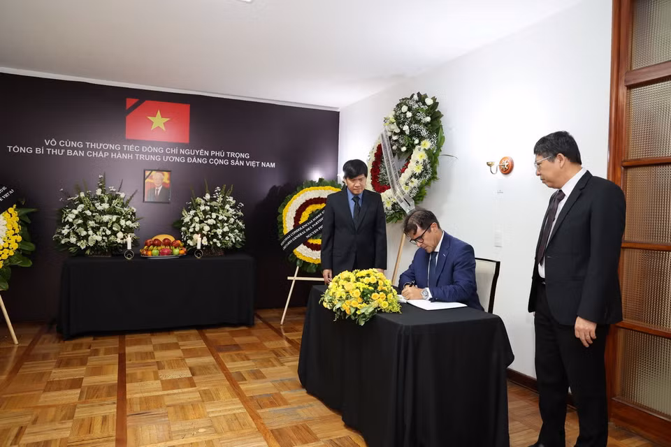 Tiến sỹ Hồ Quang Minh, Trợ lý Tổng Bí thư Đảng Lao động Mexico viết sổ tang. (Ảnh: Phi Hùng/TTXVN)