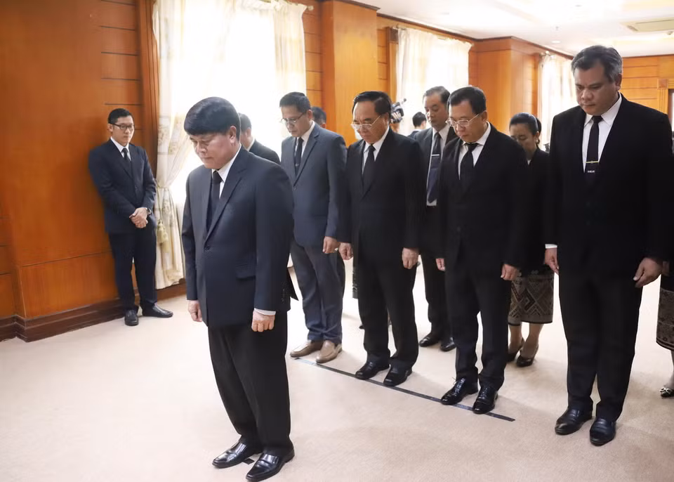 Bộ trưởng Chủ nhiệm Văn phòng Thủ tướng Lào Bouakhong Nammavong và đoàn dành phút mặc niệm tưởng nhớ Tổng Bí thư Nguyễn Phú Trọng. (Ảnh: Xuân Tú/TTXVN)