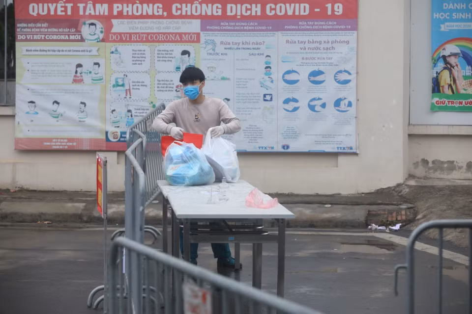 Người nhà gửi đồ tiếp tế cho người bên trong khu cách ly. (Ảnh: Minh Quyết/TTXVN)