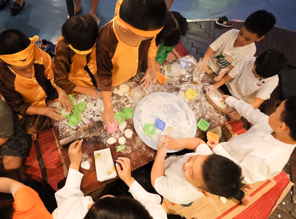Các em nhỏ cùng làm bánh Trung Thu. (Ảnh: Thanh Tùng/TTXVN)