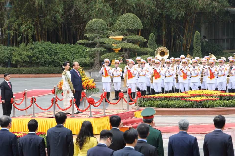 Thủ tướng Nguyễn Xuân Phúc và Cố vấn Nhà nước, Bộ trưởng Ngoại giao và Bộ trưởng Văn phòng Tổng thống nước CHLB Myanmar Aung San Suu Kyi trên bục danh dự, thực hiện nghi thức chào cờ. (Ảnh: Dương Giang/TTXVN)