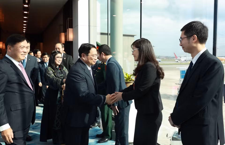 Cán bộ, nhân viên Đại sứ quán và cộng đồng người Việt Nam đón Thủ tướng Phạm Minh Chính tại sân bay Changi. (Ảnh: Dương Giang/TTXVN)