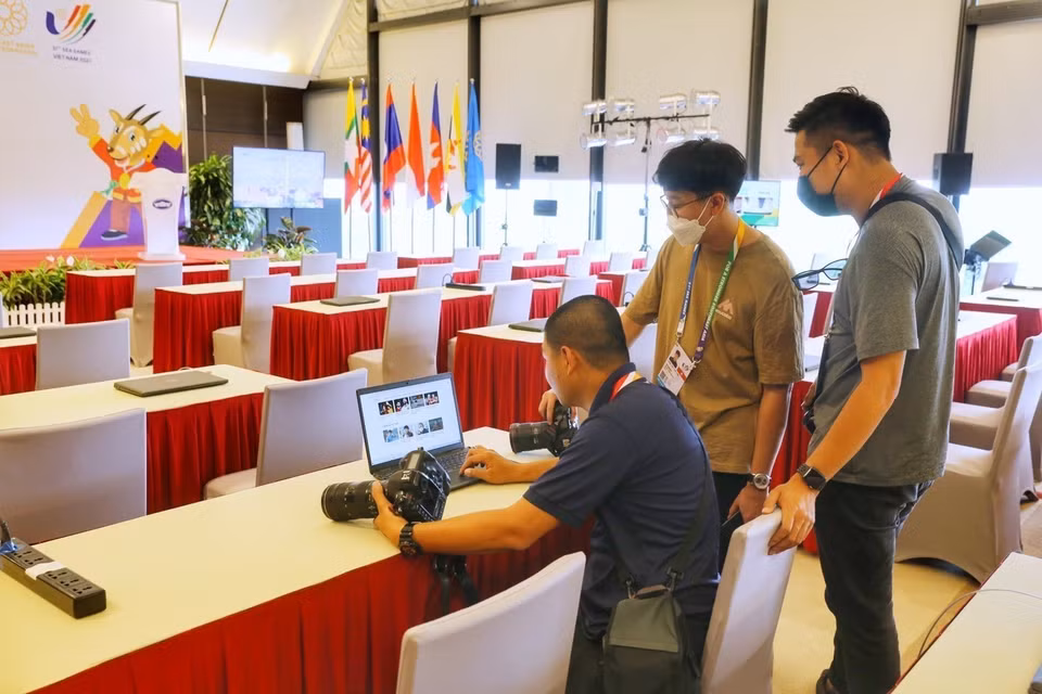 Các phóng viên tác nghiệp thử hệ thống mạng thông tin tại Trung tâm Báo chí SEA Games 31. (Ảnh: Tuấn Đức/TTXVN)
