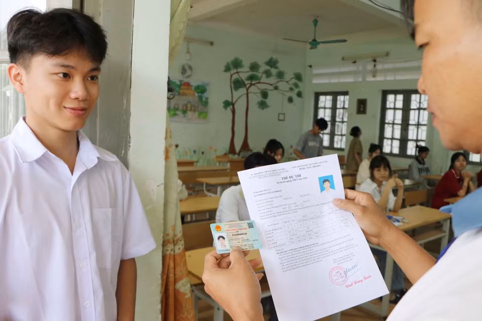 Giám thị phòng thi kiểm tra giấy tờ của các thí sinh trước khi vào phòng thi tại Trường Phổ thông Dân tộc nội trú THPT tỉnh Lai Châu. (Ảnh: Nguyễn Oanh/TTXVN)