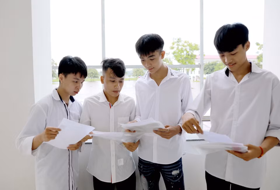 Các thí sinh tranh thủ ôn bài trước môn thi đầu tiên. (Ảnh: Hoàng Hùng/TTXVN)