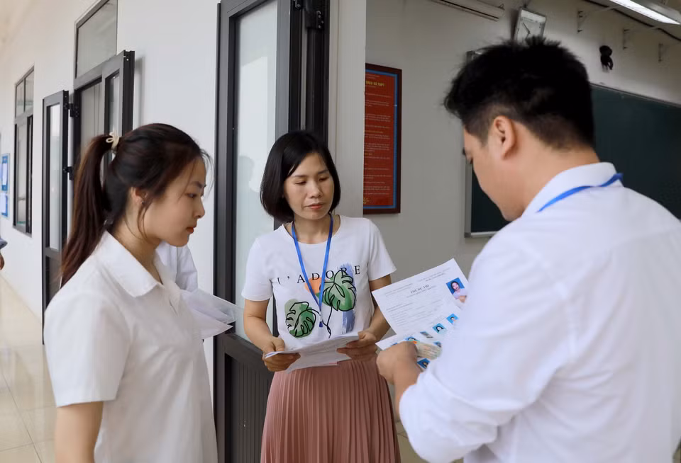 Giám thị kiểm tra thí sinh trước khi vào phòng thi tại Trường THPT Trần Hưng Đạo, huyện Tam Dương. (Ảnh: Hoàng Hùng/TTXVN)
