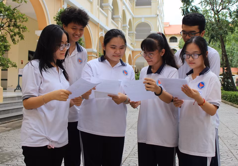 Các thí sinh tại điểm thi tại Trường THPT Nguyễn Đình Chiểu, tỉnh Tiền Giang, trao đổi thông tin trước khi làm thủ tục dự thi. (Ảnh: Hữu Chí/TTXVN)