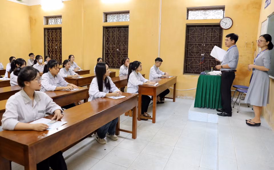 Cán bộ nhắc nhở quy chế thi cho thí sinh tại điểm thi Trường THPT Nam Trực, huyện Nam Trực. (Ảnh: Nguyễn Lành/TTXVN)