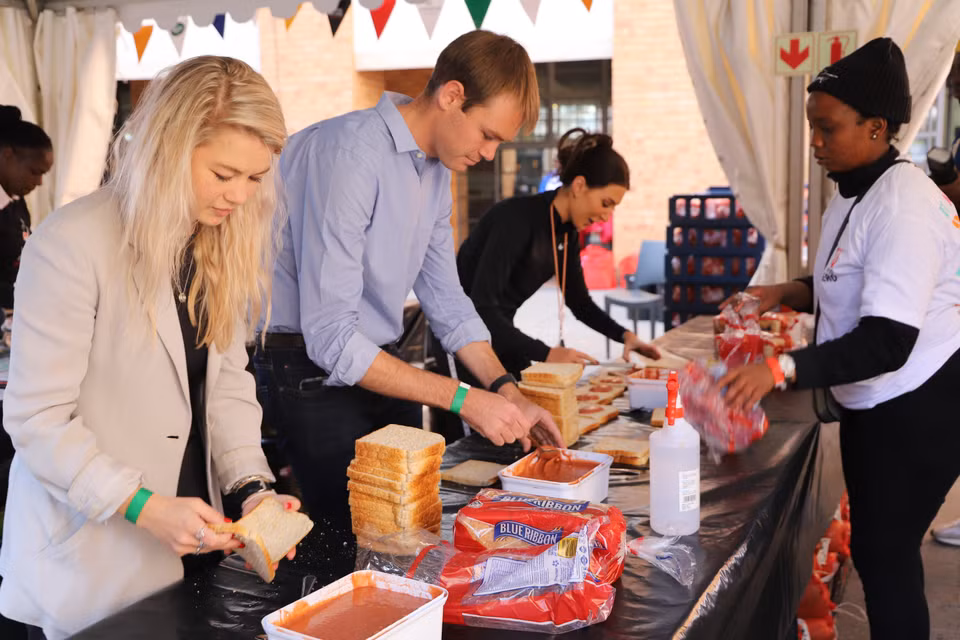 Các tình nguyện viên làm 7.000 chiếc bánh mỳ sandwich tại Quảng trường Nelson Mandela, Johannesburg. (Ảnh: Hồng Minh/TTXVN)