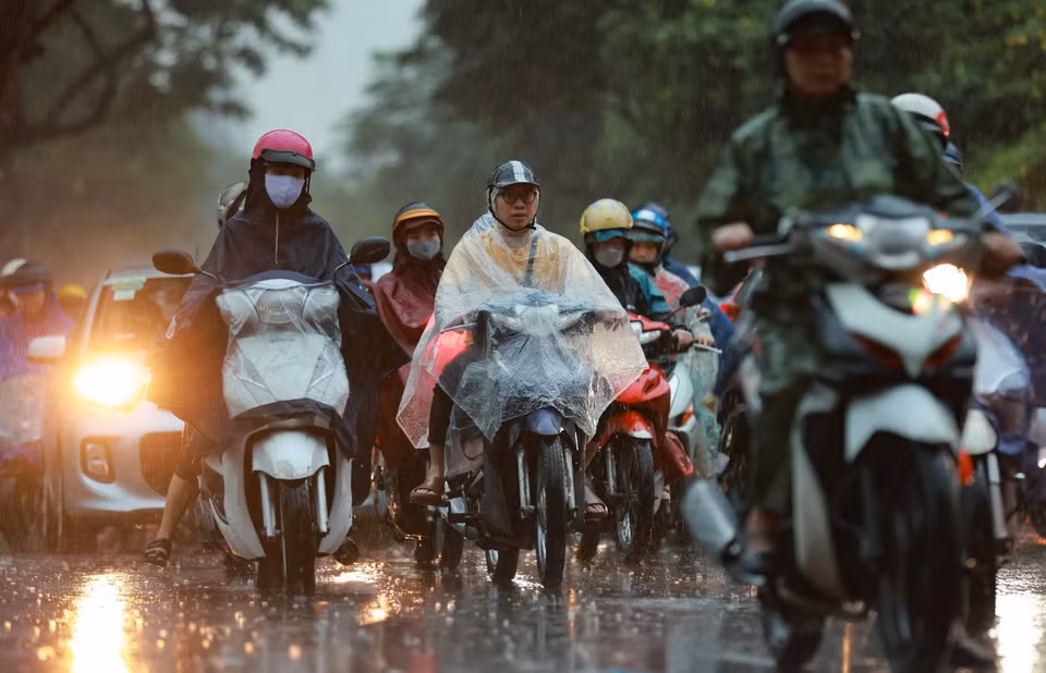 Người dân di chuyển khó khăn trong mưa vào đầu giờ sáng. (Ảnh: Thanh Tùng/TTXVN)