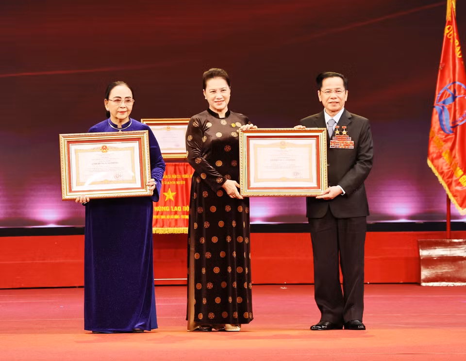 Chủ tịch Quốc hội Nguyễn Thị Kim Ngân trao danh hiệu Anh hùng Lao động thời kỳ đổi mới cho ông Lê Văn Kiểm và bà Trần Cẩm Nhung. (Ảnh: Anh Tuấn/TTXVN)