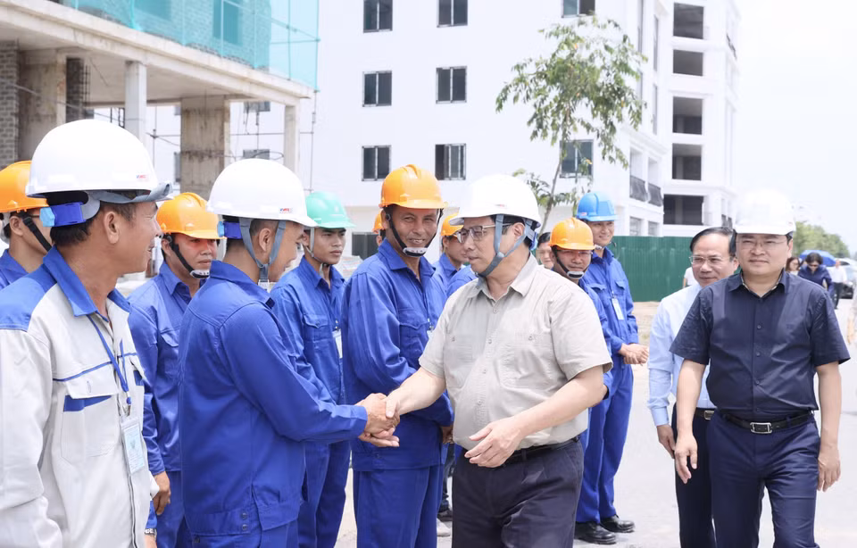 Thủ tướng Phạm Minh Chính với công nhân thi công khu nhà ở xã hội. (Ảnh: Dương Giang/TTXVN)
