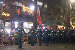 Người dân nô nức vẫy cờ chào đón đoàn diễu hành. (Ảnh: Vietnam+)