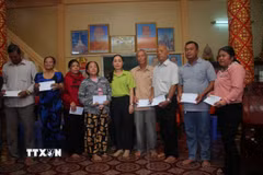 Bà Đỗ Ái Lanh, Phó Chủ tịch UBND phường Hiệp Thành, trao quà đến các hộ gia đình chính sách trên địa bàn nhân dịp lễ Sene Dolta 2026. (Ảnh: Chanh Đa/TTXVN)