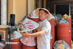 Tạ Văn Thủ livestream giới thiệu nón lá Đào Khê, đưa sản phẩm làng nghề đến gần hơn với khách hàng trên các nền tảng trực tuyến. (Ảnh: Hồng Ngọc/Vietnam+)