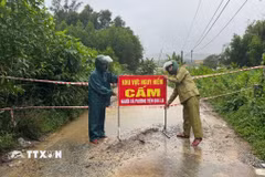 Lực lượng chức năng thành phố Đà Nẵng cắm biển cảnh báo tại những vùng bị ngập lụt do mưa lớn. (Ảnh: TTXVN phát)