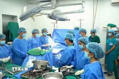 Các y bác sỹ mặc niệm tri ân người hiến tạng trước khi tiến hành lấy tạng. (Ảnh: TTXVN phát)