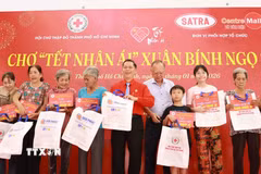 Đại diện Hội Chữ thập đỏ Thành phố Hồ Chí Minh tặng quà cho các gia đình khó khăn tại sự kiện Chợ Tết Nhân ái Xuân Bính Ngọ 2026. (Ảnh: Đinh Hằng/TTXVN)