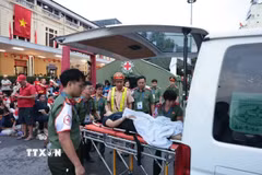 Lực lượng chức năng hỗ trợ chăm sóc sức khỏe một người dân bị ngất trên phố Lê Duẩn ngày 30/8. (Ảnh: Trần Việt/TTXVN)