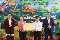 Lãnh đạo xã Khổng Lào trao quà Tết cho đại diện bản Nà Vàng. (Ảnh: Quý Trung/TTXVN)