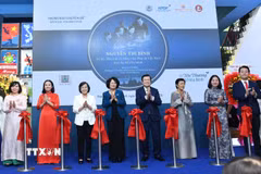 Các đại biểu thực hiện nghi thức cắt băng khai mạc trưng bày chuyên đề. (Ảnh: Thu Hương/TTXVN)