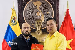Đại sứ Việt Nam tại Venezuela tặng quà lưu niệm cho Giáo sư José Javier Díaz Macadan. (Ảnh: TTXVN phát)