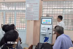 Cán bộ Trung tâm Phục vụ hành chính công xã Phú Lâm (tỉnh An Giang) hướng dẫn người dân các thao tác gửi, kiểm tra hồ sơ thủ tục hành chính bằng kiốt thông minh. (Ảnh: Công Mạo/TTXVN)