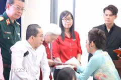Đại diện Ban tổ chức tặng quà nạn nhân chất độc da cam/dioxin Thành phố Hồ Chí Minh. (Ảnh: Thanh Vũ/TTXVN)