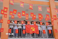 Học sinh Trường Phổ thông nội trú Tiểu học và THCS Sam Mứn tươi vui bên những lá cờ Đảng, cờ Tổ quốc được trang trí trên hành lang. (Ảnh: Xuân Tư/TTXVN)