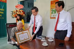 Ông Đoàn Minh Huấn, Ủy viên Bộ Chính trị, Giám đốc Học viện Chính trị Quốc gia Hồ Chí Minh trao chứng nhận 80 năm tuổi Đảng cho đảng viên Phạm Duy Khương. (Ảnh: Thanh Liêm/TTXVN)