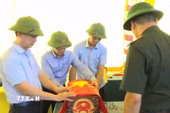 Lãnh đạo xã Vĩnh Bảo cùng lực lượng chức năng tiếp nhận, bảo quản các bộ hài cốt. (Ảnh: Hoàng Ngọc/TTXVN)