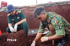Lực lượng chức năng tìm kiếm, quy tập hài cốt liệt sỹ tại xã Minh Đức, thành phố Đồng Nai. (Ảnh: Đậu Tất Thành/TTXVN)