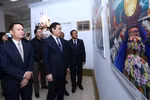 Phó Thủ tướng Vương Đình Huệ (giữa), Tổng Giám đốc Thông tấn xã Việt Nam Nguyễn Đức Lợi (trái) cùng các đại biểu tham quan triển lãm. (Ảnh: Quang Quyết/TTXVN)