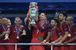 Cristiano Ronaldo (giữa) cùng các đồng đội trong niềm vui chiến thắng khi nâng cao chiếc cúp vô địch EURO 2016. (Nguồn: AFP/TTXVN)