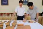 Các nhà nghiên cứu chia sẻ thông tin về những hiện vật được khai quật. (Ảnh: Quốc Dũng/TTXVN)