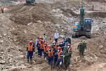 Lực lượng chức năng đưa thi thể nạn nhân ra khỏi hiện trường. (Ảnh: TTXVN phát)