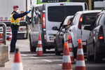 Cảnh sát Hungary kiểm tra thân nhiệt của tài xế tại khu vực cửa khẩu giữa Hungary-Áo, nhằm ngăn chặn sự lây lan của dịch COVID-19. (Ảnh: AFP/TTXVN)