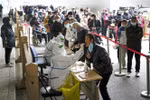 Nhân viên y tế lấy mẫu xét nghiệm COVID-19 cho người dân tại Bắc Kinh, Trung Quốc. (Ảnh: Kyodo/TTXVN)