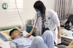 Bác sỹ khám cho các học sinh bị nghi ngộ độc thực phẩm sau khi ăn cơm cuộn bán trước cổng trường. (Ảnh: Đinh Hằng/TTXVN)