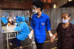 Người cao tuổi được đội ngũ thanh niên tình nguyện chăm sóc tận tình tại điểm tiêm vaccine phòng COVID-19. (Ảnh: Lâm Khánh/TTXVN)