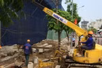 Công ty cổ phần Phương Bắc đang thực hiện đào đất để đổ bê tông trụ móng, đưa cẩu tháp vào phá dỡ 8B Lê Trực. (Ảnh Mạnh Khánh/TTXVN)