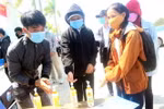 Các thí sinh đều nghiêm túc rửa tay bằng dung dịch sát khuẩn trước khi vào làm thủ tục thi. (Ảnh: Trịnh Bang Nhiệm/TTXVN)