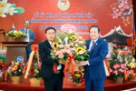 Đại sứ Việt Nam tại Lào Nguyễn Bá Hùng tặng hoa chúc mừng 15 năm thành lập Tổng hội. (Ảnh: Phạm Kiên/TTXVN)