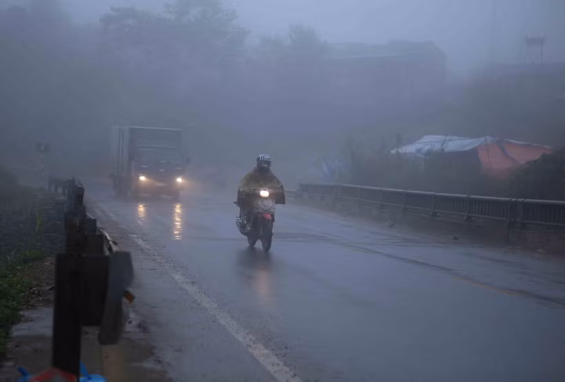Các phương tiện di chuyển chậm do trời mưa phùn cộng thêm sương mù. (Ảnh: Quý Trung/TTXVN)